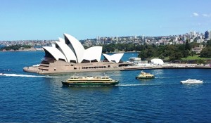 The Sydney Opera House in the busy Sydney Harbor. Notice the city spread out behind.